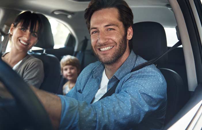 Famille souriante en voiture